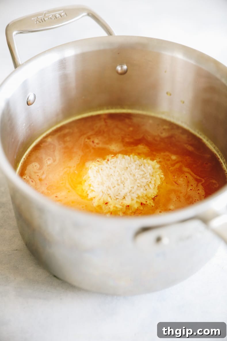 Fragrant Golden Saffron Rice 4 Fluffy, golden basmati saffron rice cooking gently in a lidded pot on the stove.
