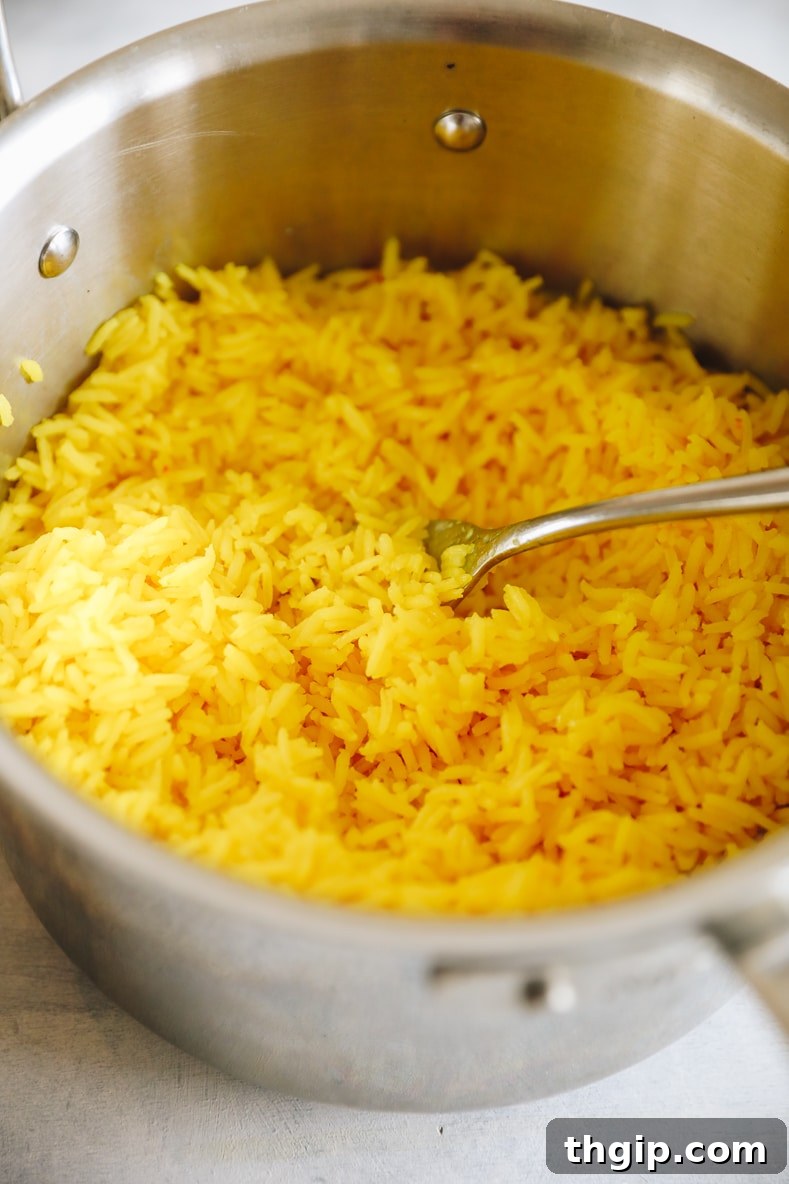 Fragrant Golden Saffron Rice 5 Perfectly cooked, vibrant saffron rice fluffed and ready in a metal pot.