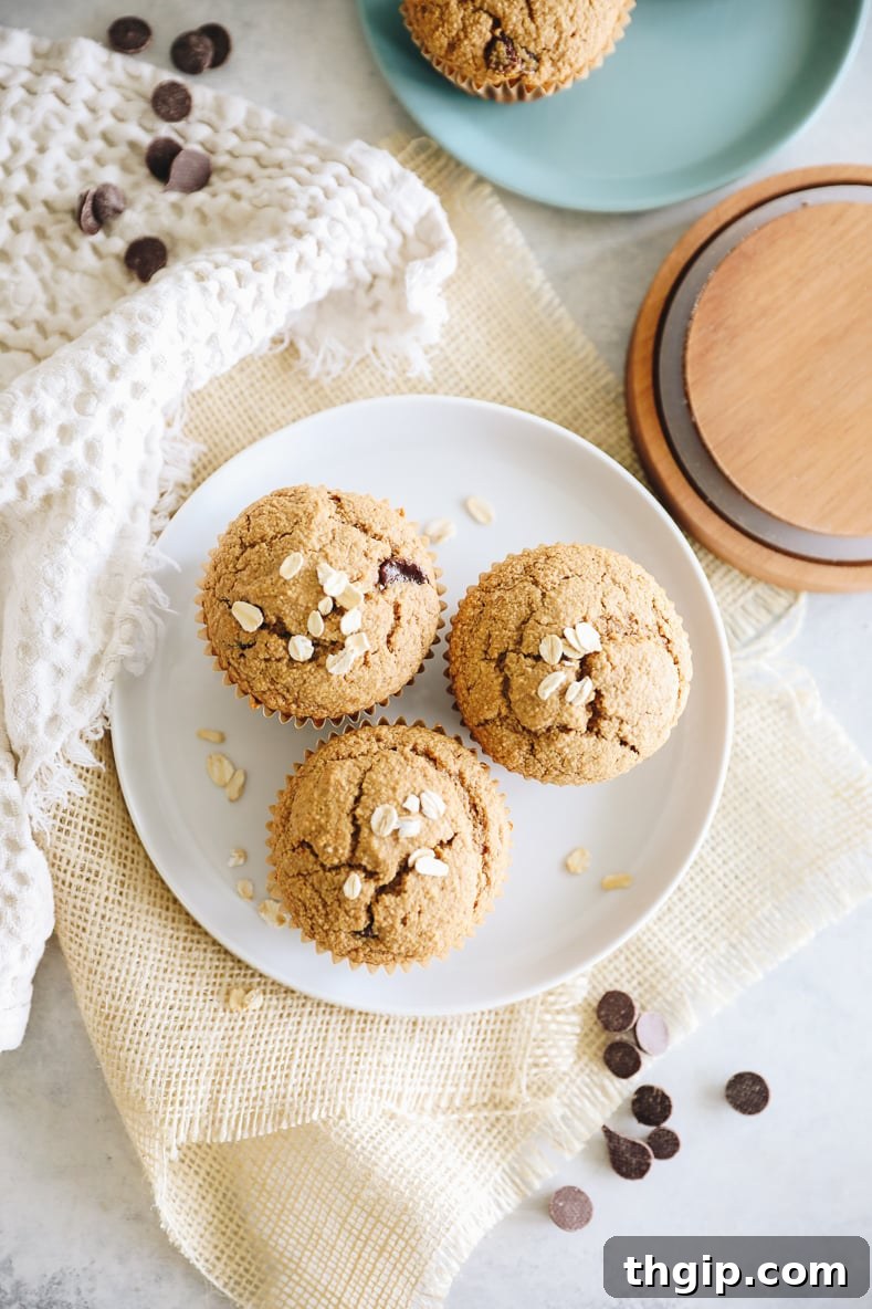 A close-up of a delicious oat flour muffin on a white plate, highlighting its texture.