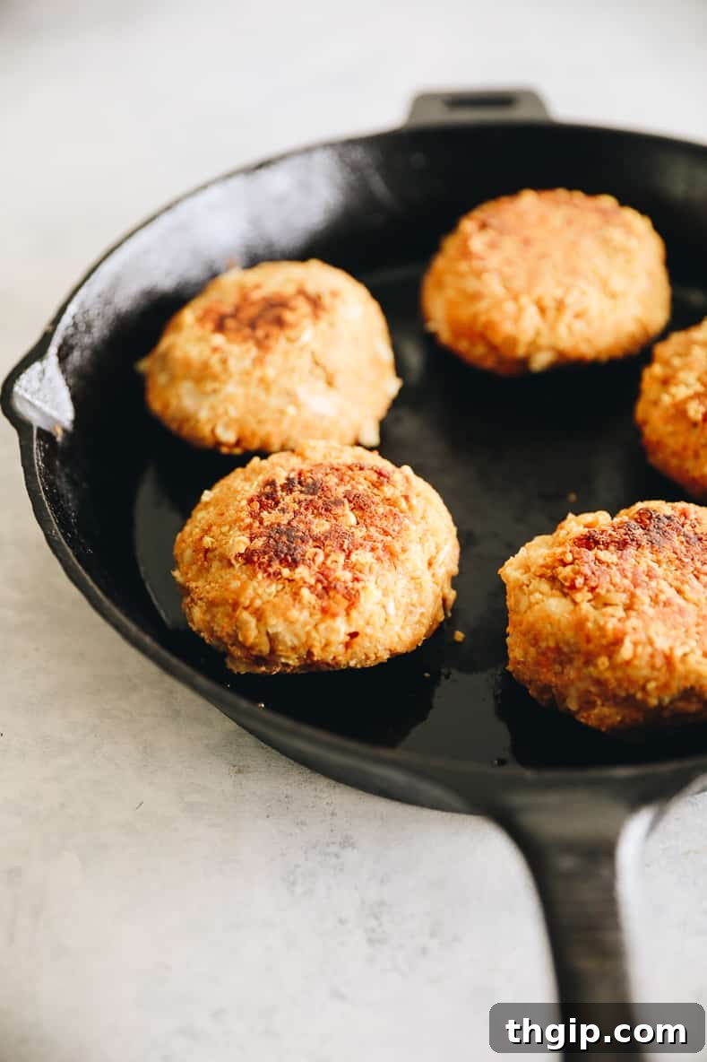 Wholesome Quinoa Veggie Burgers 6 Quinoa burger patties cooking in a hot skillet until golden brown.