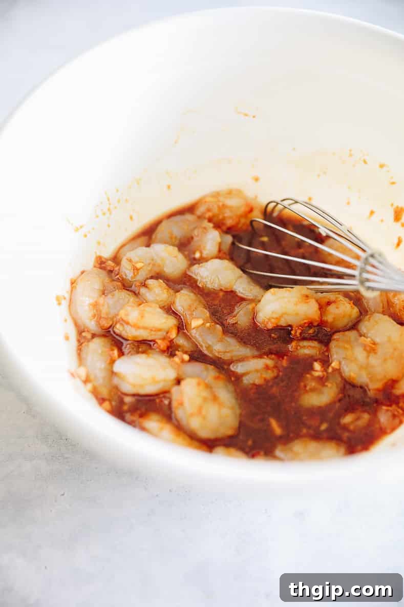 Sizzling Sesame Shrimp with Crisp Vegetable Stir-Fry 5 Shrimp marinating in a bowl with spicy sesame sauce