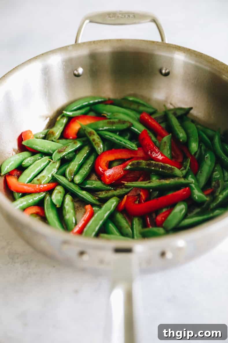 Sizzling Sesame Shrimp with Crisp Vegetable Stir-Fry 6 Snap peas and bell peppers cooking in a hot pan for stir fry