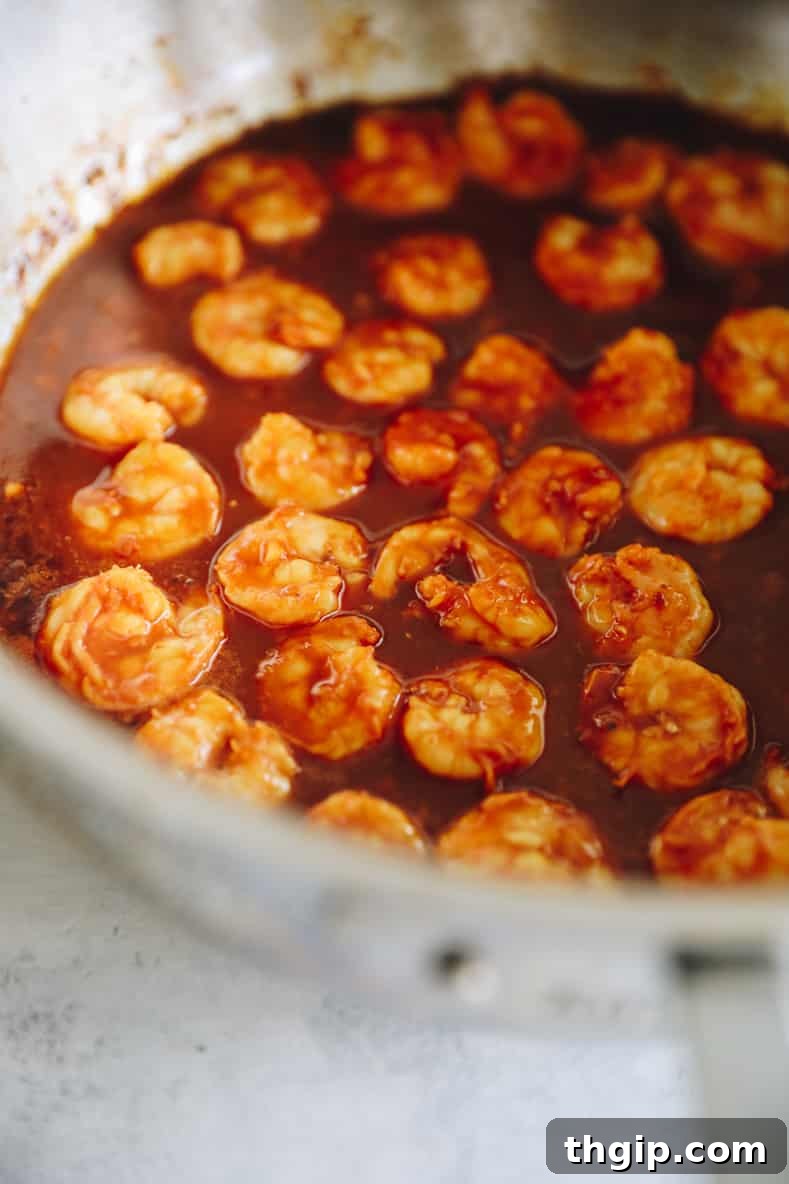 Sizzling Sesame Shrimp with Crisp Vegetable Stir-Fry 7 Shrimp cooking in the pan with stir fry sauce, turning opaque