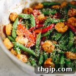 Sauté pan with spicy sesame shrimp and veggie stir fry.
