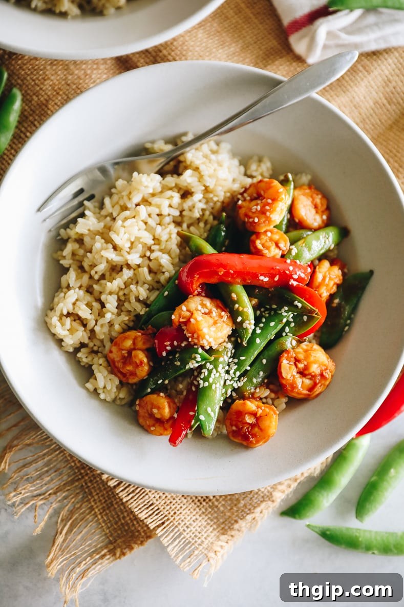 Sizzling Sesame Shrimp with Crisp Vegetable Stir-Fry 10 A beautifully plated serving of spicy sesame shrimp stir fry with chopsticks