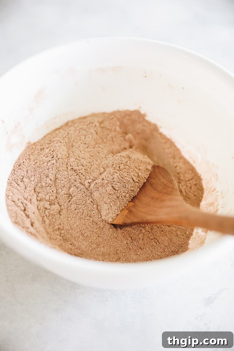 Garden Gem Chocolate Muffins 4 A bowl filled with dry ingredients: white flour, whole wheat flour, cocoa powder, baking soda, and salt, ready to be mixed for chocolate zucchini muffins.