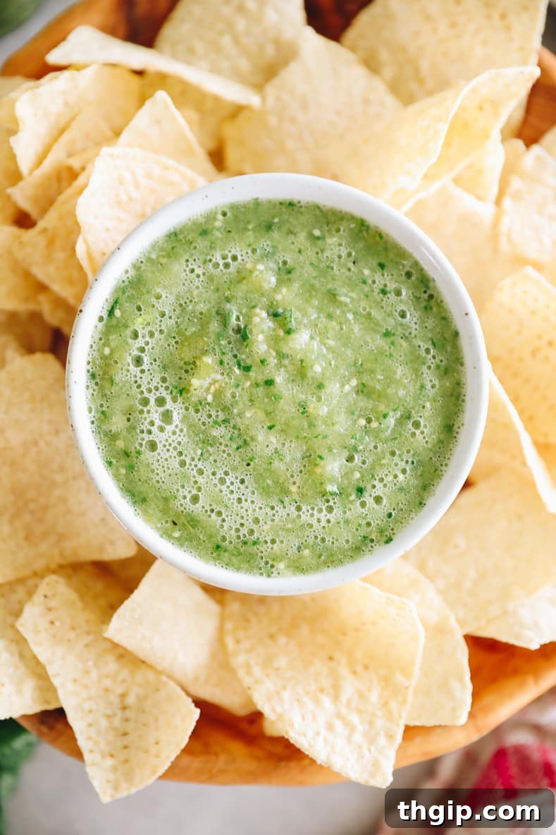 Fresh and Easy Salsa Verde 6 A bowl of green salsa served with tortilla chips and a garnish of cilantro.