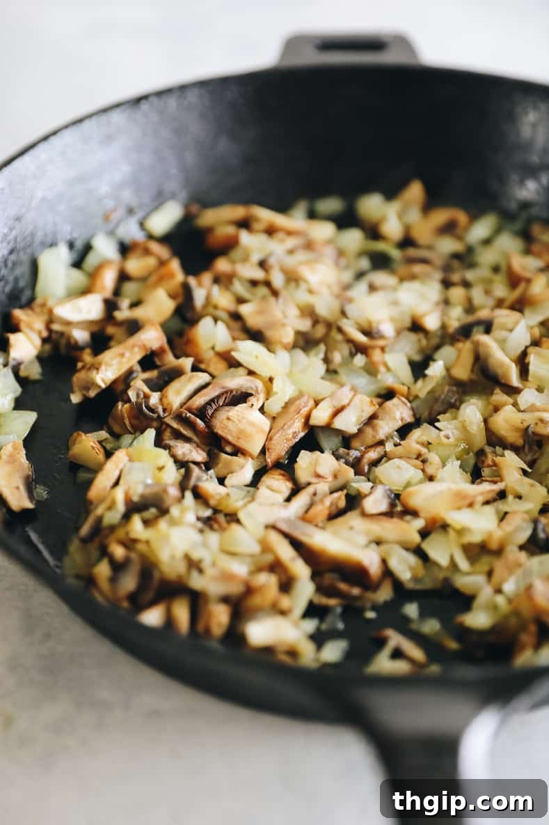 Sautéing onions and mushrooms in a skillet for egg muffins.