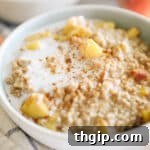 Oatmeal with peaches and cinnamon in a white bowl.