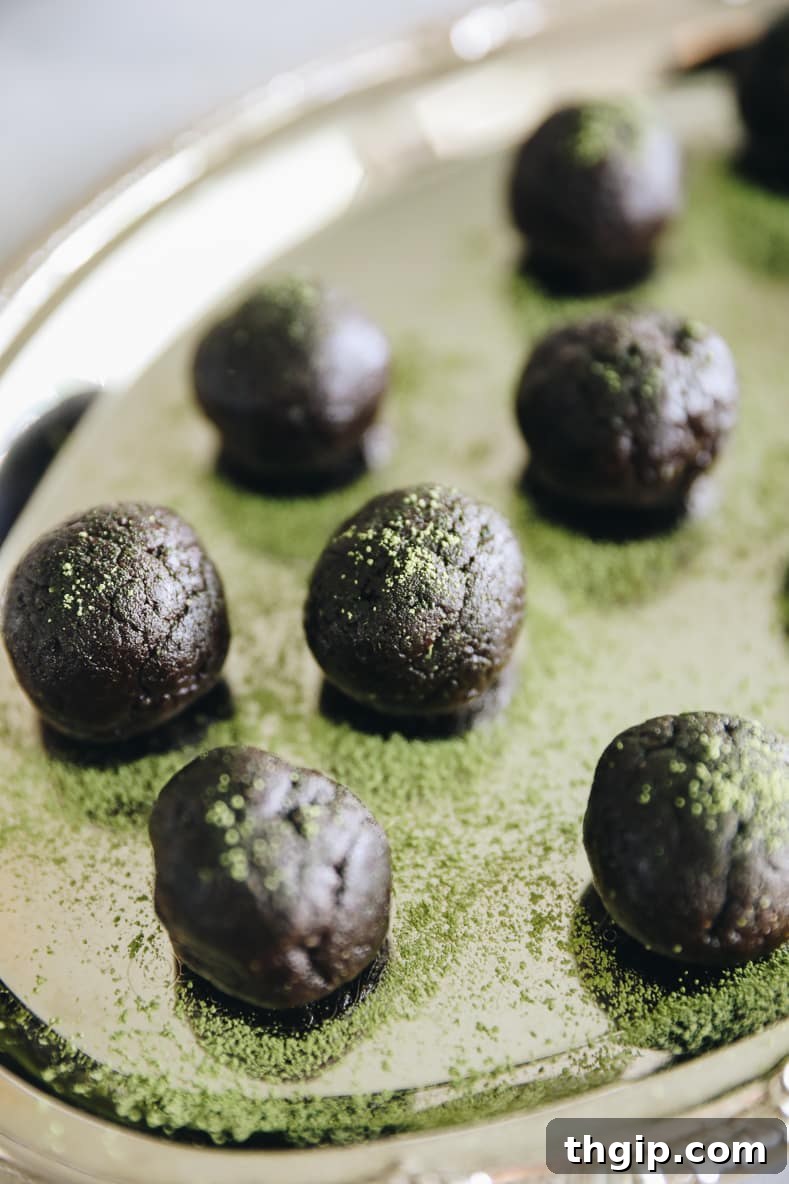 Matcha Chocolate Power Bites 5 Finished Chocolate Matcha Energy Balls neatly arranged in a bowl, dusted with matcha powder, showcasing the final product.