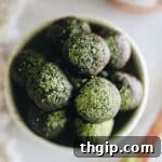 Overhead shot of matcha chocolate energy balls in a white bowl.