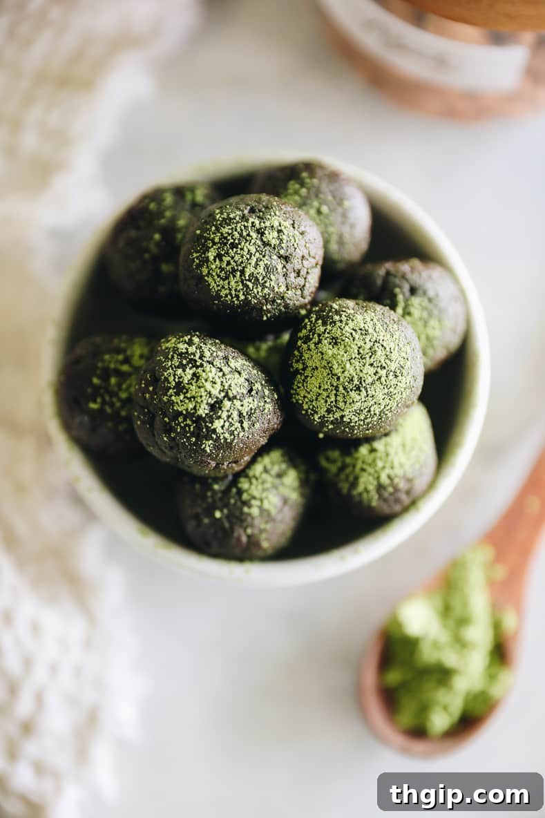 Matcha Chocolate Power Bites 6 Another overhead shot of Chocolate Matcha Energy Balls, some neatly arranged, others slightly scattered, with a light dusting of green matcha powder.