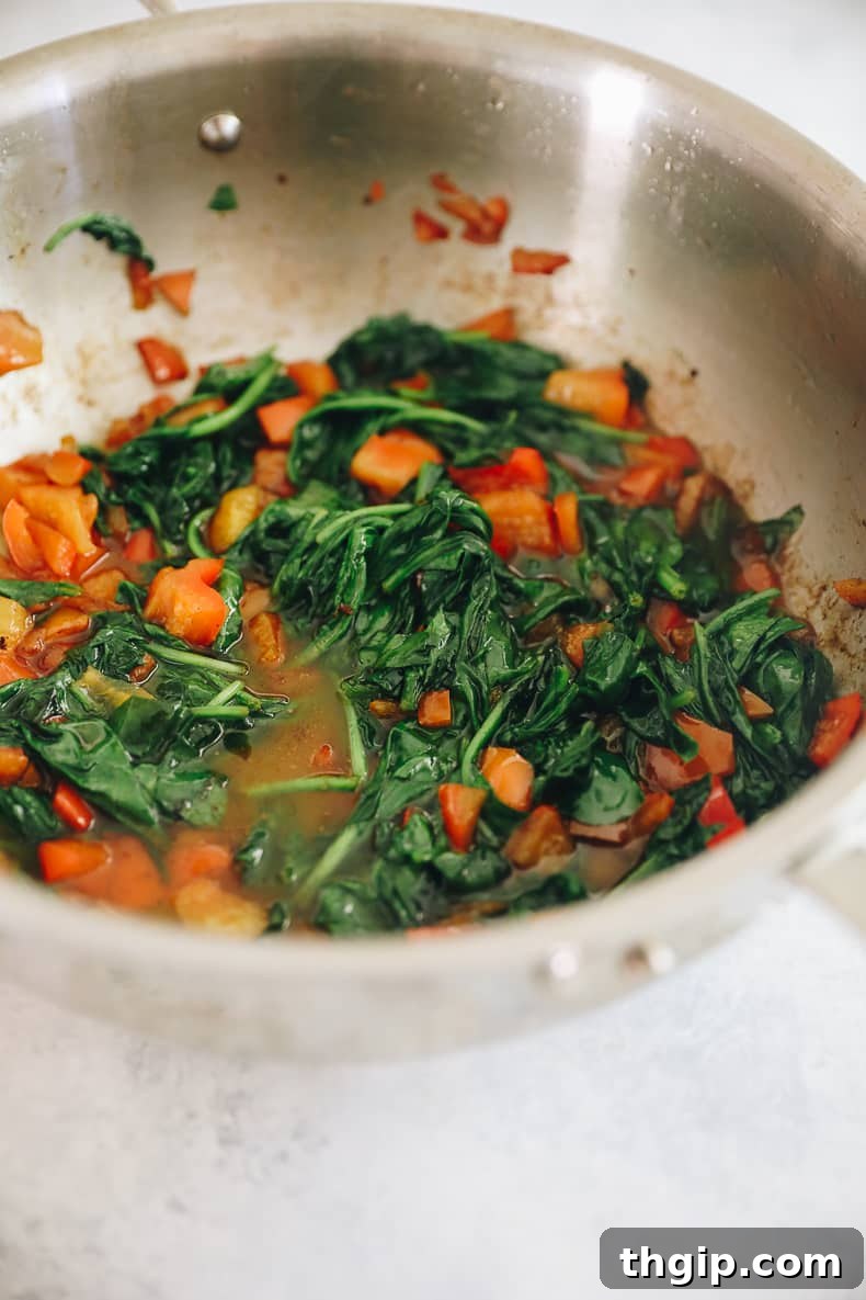 Grab-and-Go Frozen Breakfast Burritos 5 Fresh bell pepper and spinach sautéing in a pan, ready to add vibrant flavor to breakfast burritos.