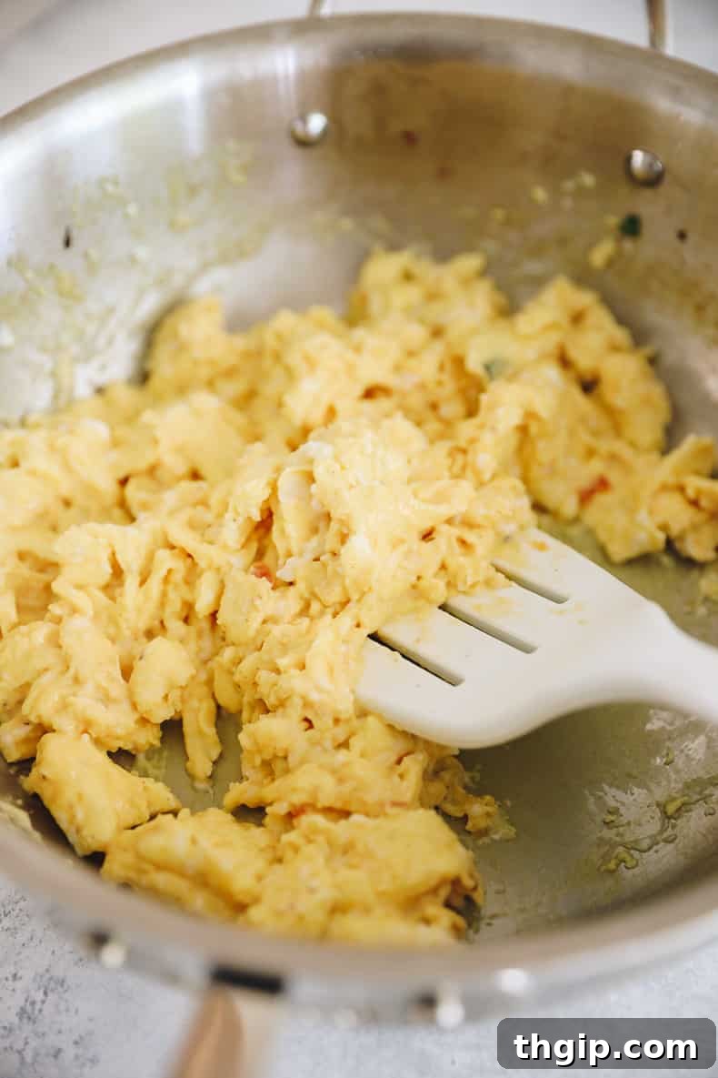 Grab-and-Go Frozen Breakfast Burritos 6 Fluffy scrambled eggs cooking in a pan, forming a key component for delicious freezer breakfast burritos.