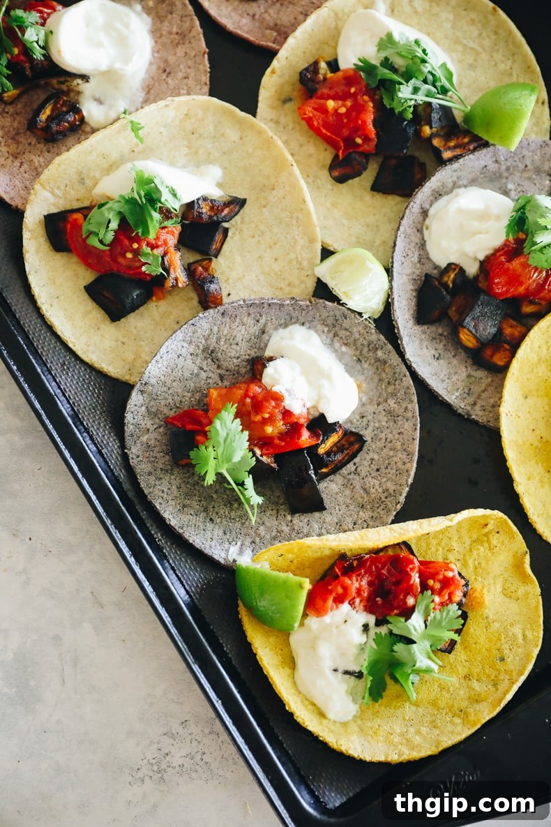 Charred Eggplant Tacos with Burst Tomatoes and Burrata 2 eggplant tacos laid out on a baking sheet
