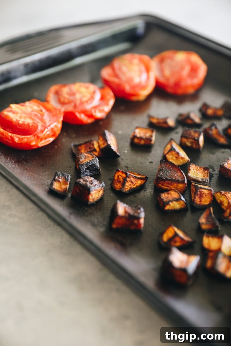 Charred Eggplant Tacos with Burst Tomatoes and Burrata 4 Roasted eggplant and tomatoes on a baking sheet