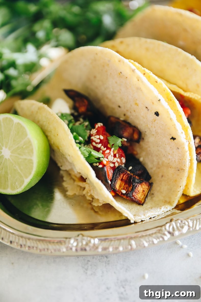 Charred Eggplant Tacos with Burst Tomatoes and Burrata 6 Roasted eggplant tacos on a silver tray