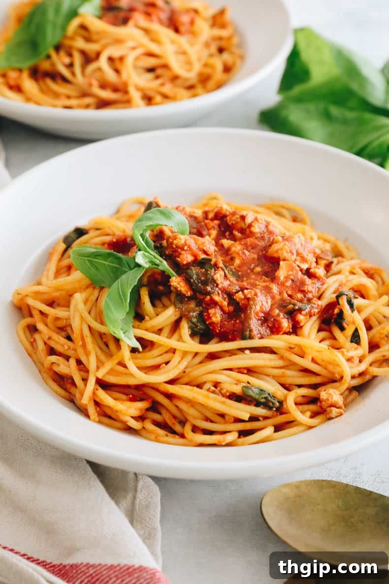 Savory Tofu Bolognese Pasta 2 A vibrant bowl of vegan tofu pasta with rich tomato sauce, garnished with fresh basil.