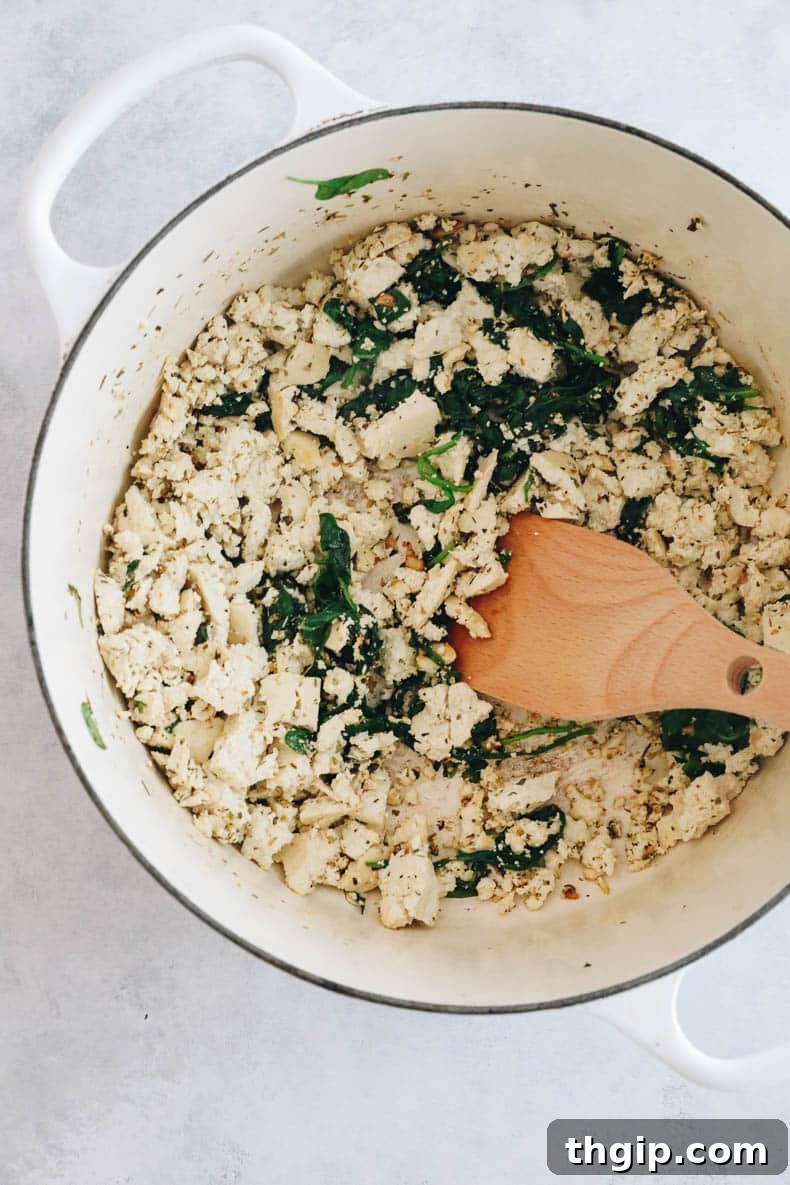 Savory Tofu Bolognese Pasta 5 Crumbled tofu, spinach, and garlic sautéing in a Dutch oven, cooking down for the pasta bolognese.