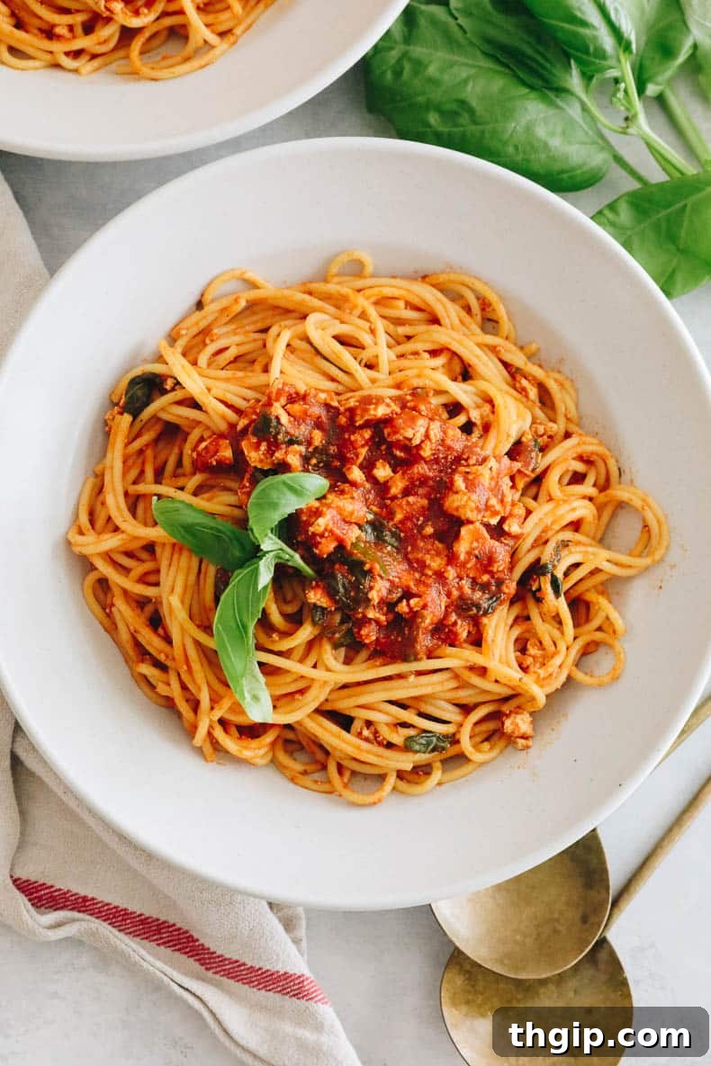 Savory Tofu Bolognese Pasta 9 A beautifully presented bowl of tofu pasta with fresh basil on top, ready to eat.
