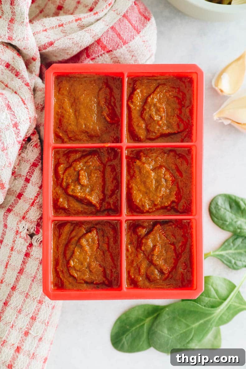 Secret Garden Pasta Sauce 7 Hidden veggie tomato sauce portioned into a red 3 oz silicone ice cube tray, ready for freezing individual servings.