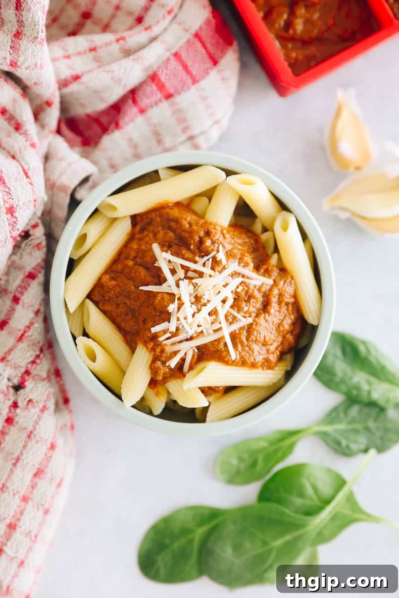 Secret Garden Pasta Sauce 9 Overhead photograph of penne pasta in a baby bowl with a generous serving of homemade hidden veggie tomato sauce and sprinkled parmesan cheese, ready to eat.