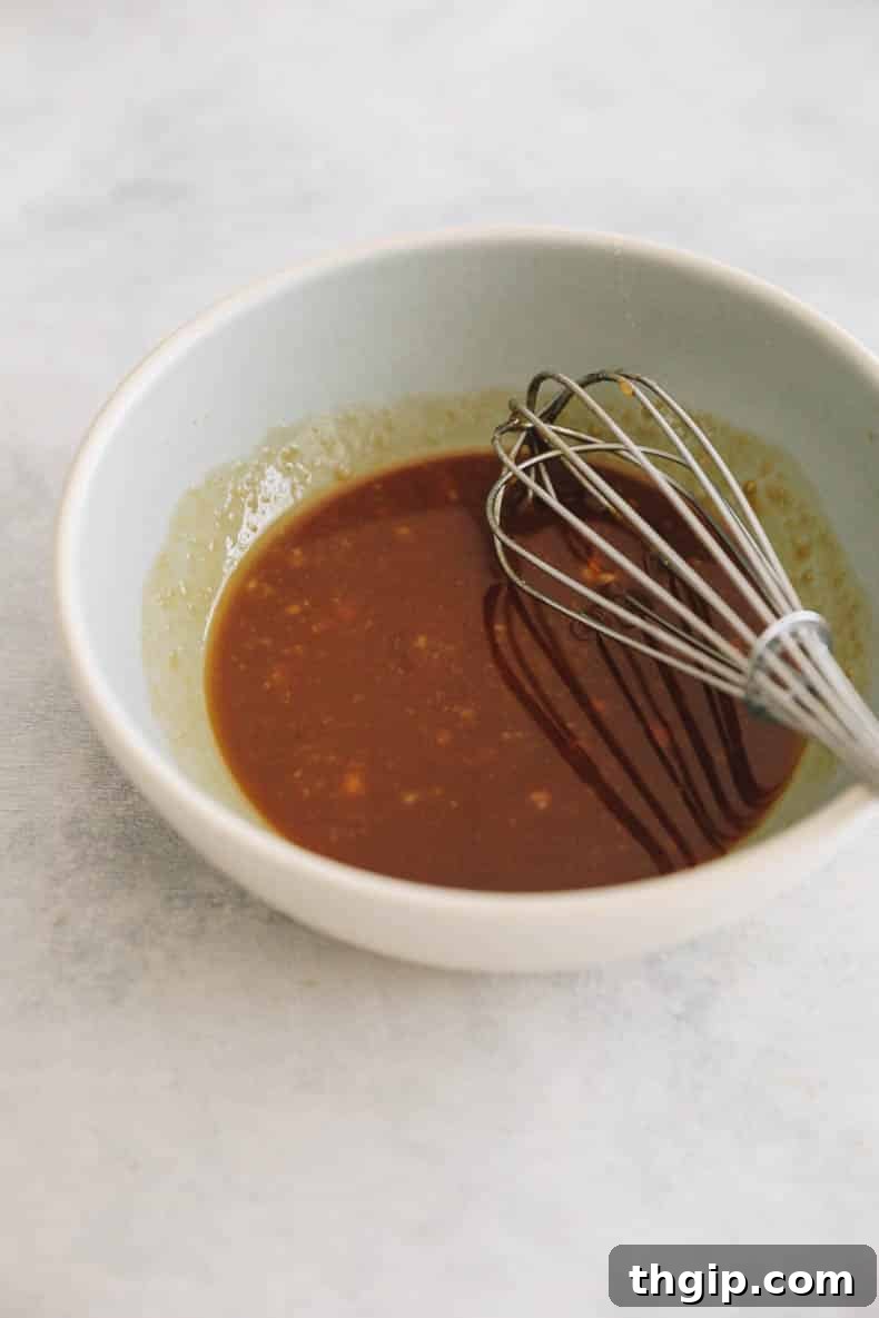 Effortless Miso Glazed Salmon 4 miso glaze for salmon in a small bowl with a whisk.