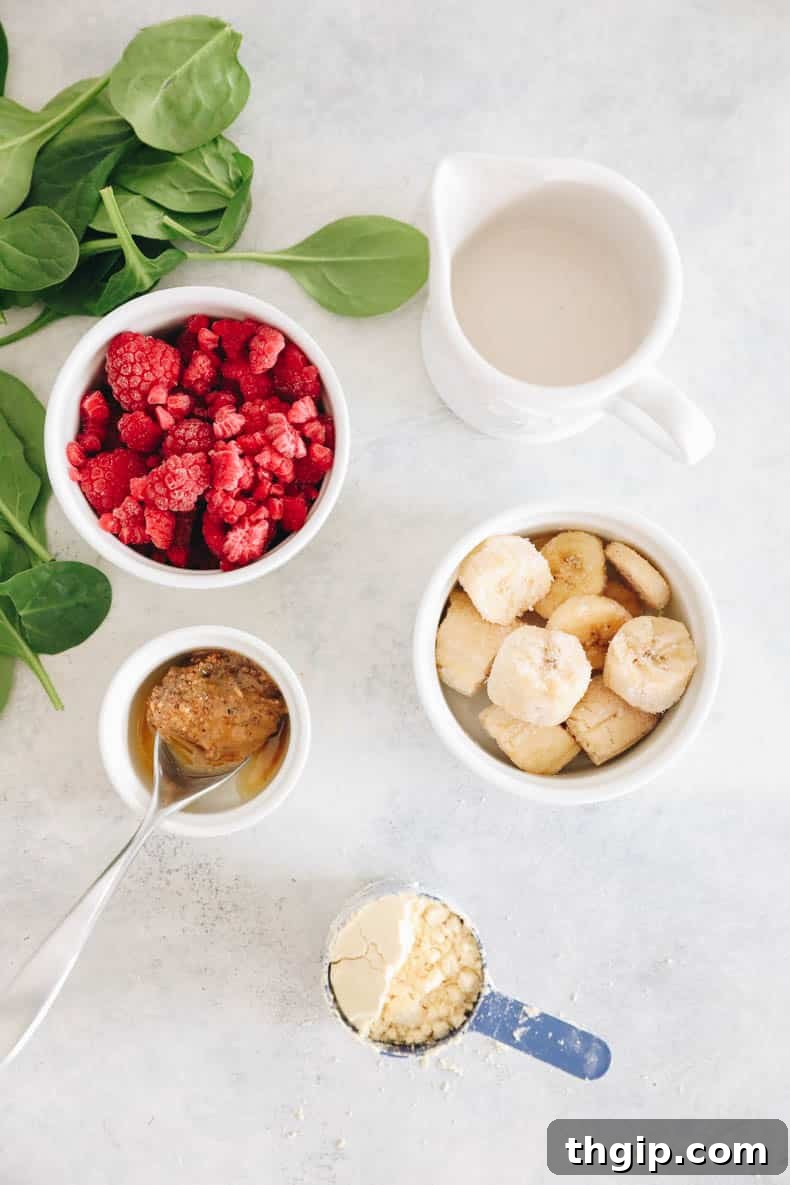 Vibrant Bowl Blends 3 A flat lay of fresh and frozen ingredients for a healthy smoothie bowl: frozen berries, sliced frozen bananas, a bottle of almond milk, a jar of nut butter, fresh spinach, and a scoop of protein powder.