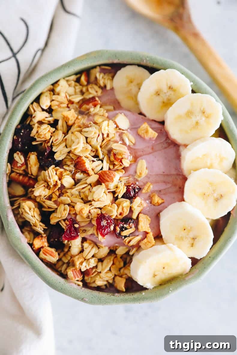 Vibrant Bowl Blends 6 An inviting overhead shot of a vibrant pink raspberry smoothie bowl, richly topped with crunchy granola and fresh banana slices, highlighting a perfect healthy breakfast.