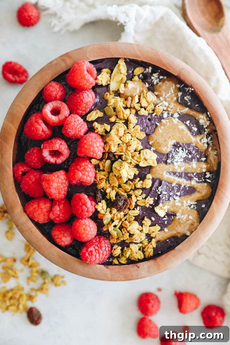 Superfood Acai Bliss Bowl 7 overhead shot of an acai bowl topped with raspberries, granola and nut butter.