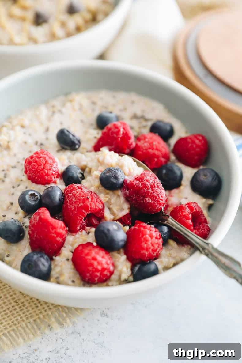 steel cut overnight oats in a bowl topped with raspberries, blueberries and chia sseds.