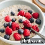 bowl of oatmeal with blueberries and raspberries and spoon.