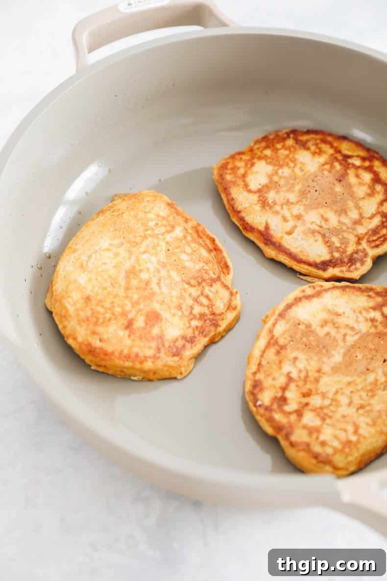 Golden Yam Griddlecakes 7 sweet potato pancakes in a skillet.