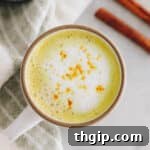 Overhead view of a beautiful turmeric latte in a white and brown mug, ready to be enjoyed.