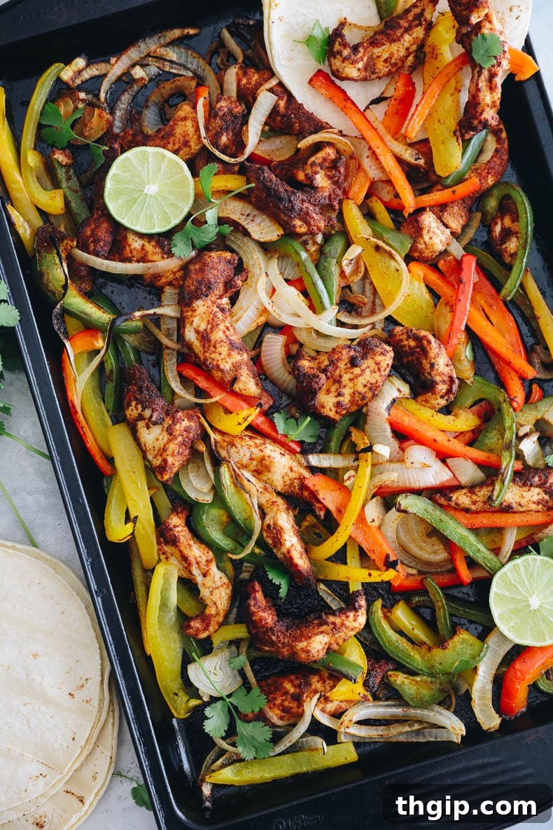 Effortless Fajita Feast 2 Vibrant sheet pan chicken fajitas with roasted onions and bell peppers, ready to be served in tortillas.