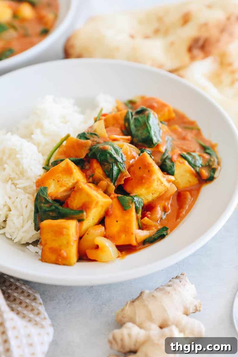 Golden Coconut Tofu Curry 2 Tofu curry in a shallow bowl with rice, garnished with fresh cilantro.