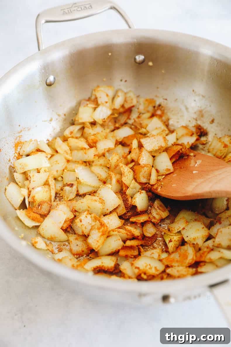 Golden Coconut Tofu Curry 4 Onions, garlic, and spices cooking in a pot, creating an aromatic base.
