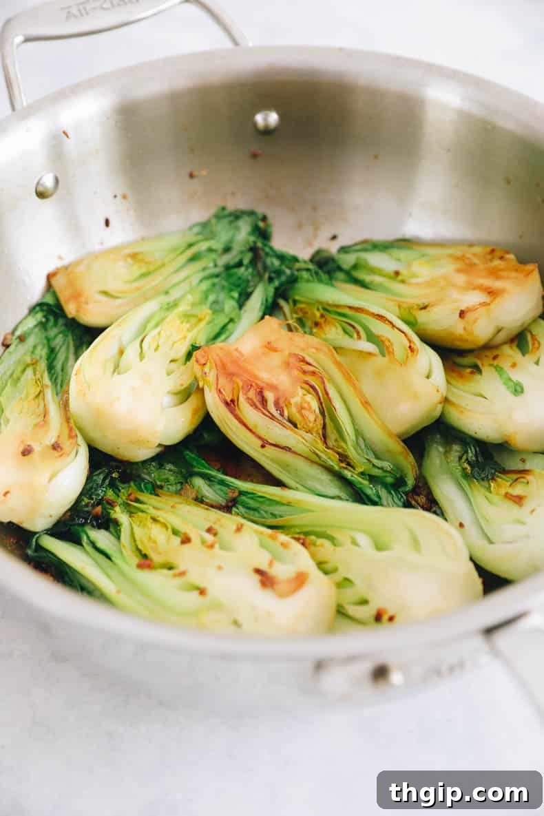 Garlicky Baby Bok Choy Sauté 5 Cooked baby bok choy in a pan, lightly browned and wilted.