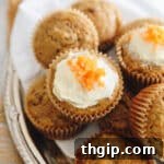 Carrot cake muffins stacked on a plate.