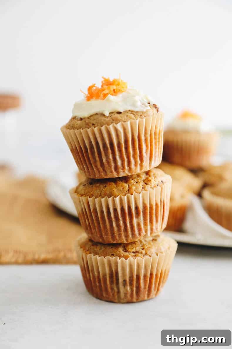 Carrot Cake Bites 9 Close-up of a carrot cake muffin with frosting, surrounded by other muffins.