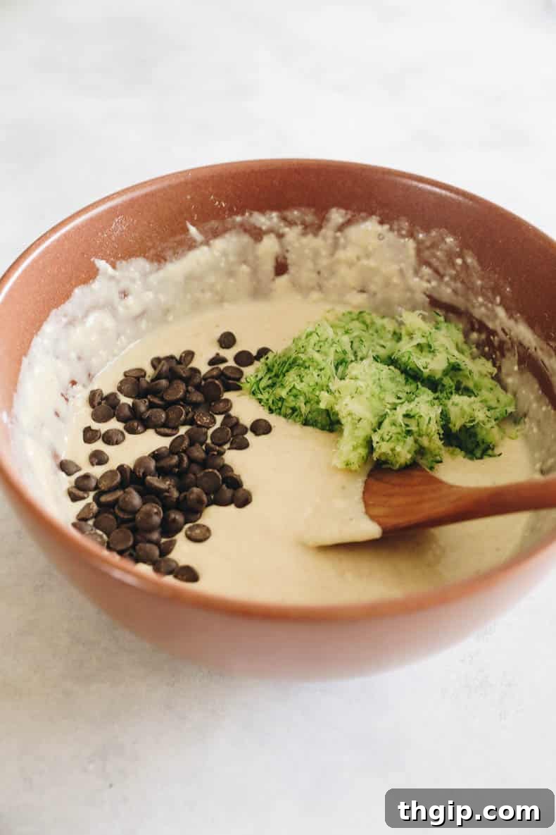 Zucchini pancake batter with grated zucchini and chocolate chips folded in.