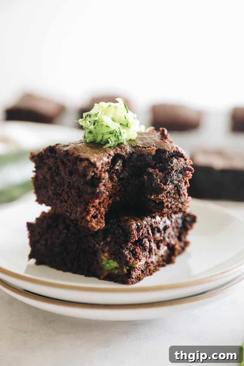Zesty Zucchini Brownies 9 A close-up of a zucchini brownie with a bite taken out, revealing its dense, fudgy interior and inviting texture.
