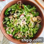 large brown bowl with spring mix salad.