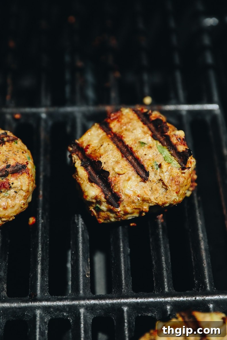 Perfect Turkey Burgers Every Time 5 burgers cooking on a grill.