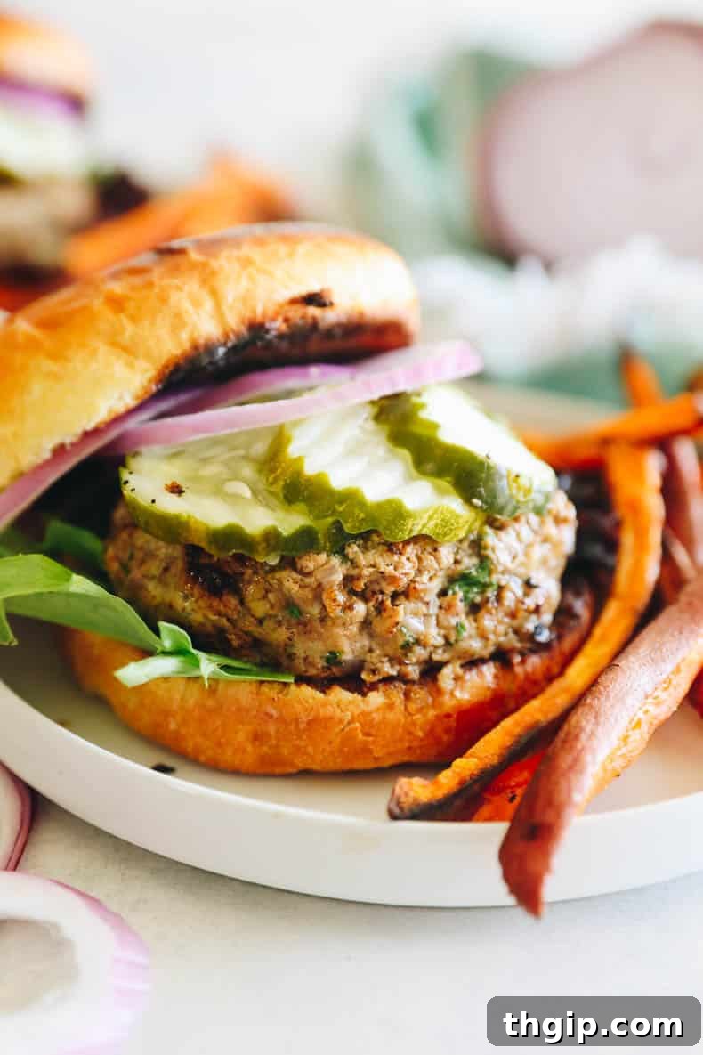 Perfect Turkey Burgers Every Time 6 turkey burgers on a bun with pickles and onions.