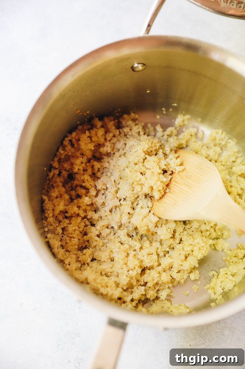 Close-up photo of perfectly cooked, fluffy quinoa resting in a pot, ready to be served.
