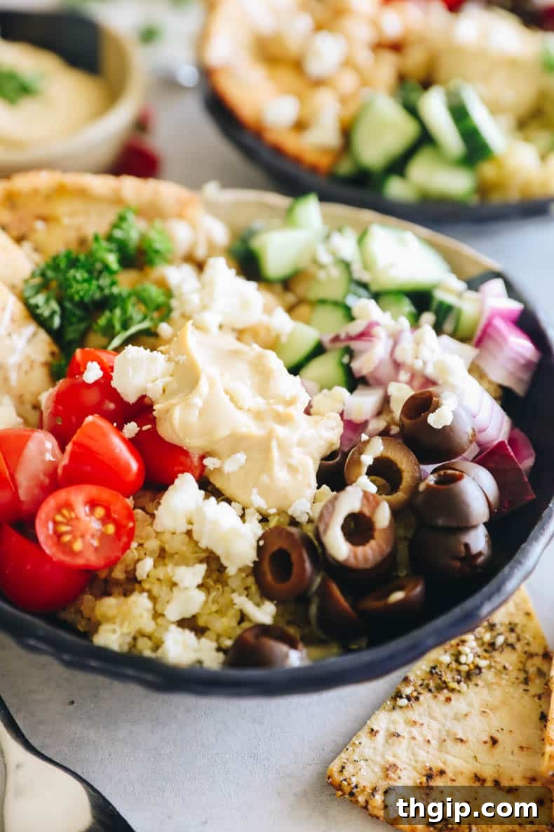 A close-up view of a fully assembled Mediterranean bowl, showcasing the vibrant ingredients and inviting textures, drizzled with tahini sauce.