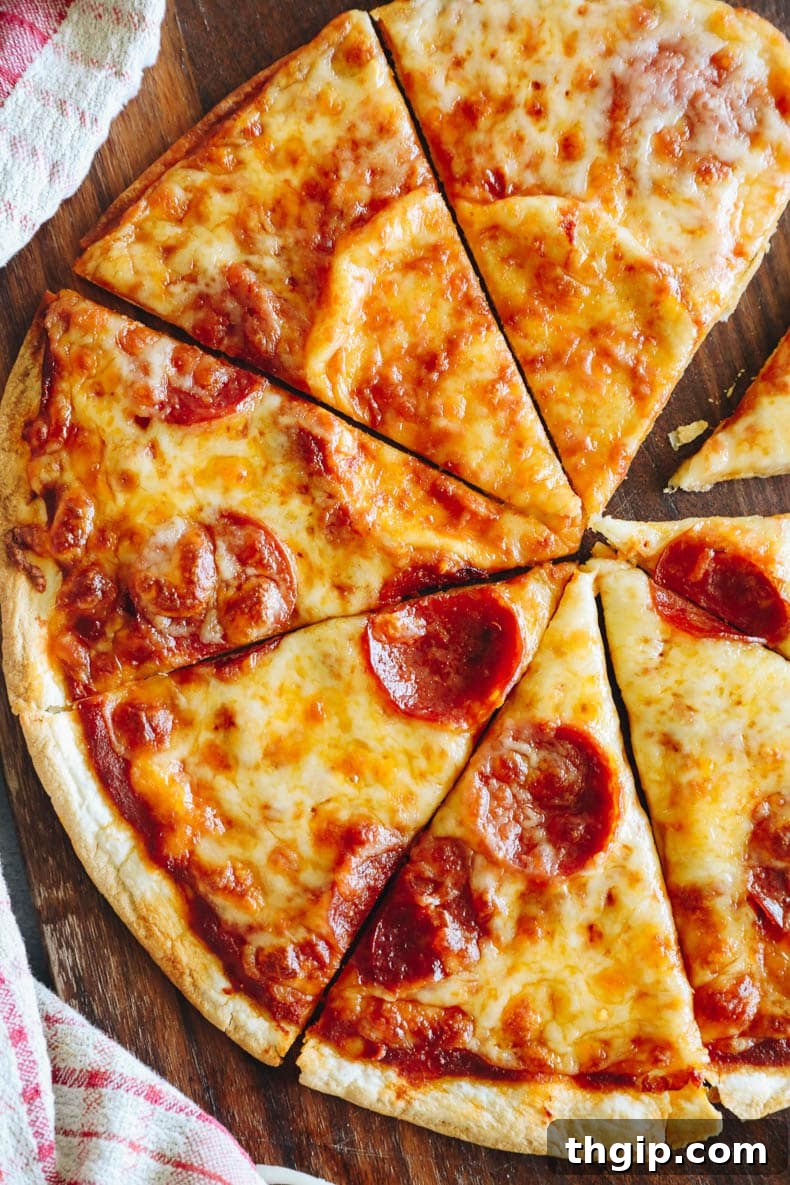 Crispy Tortilla Pizza 4 Baked tortilla pizza with pepperoni, sliced and ready on a cutting board.