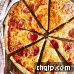 Pepperoni tortilla pizza cut into slices on a cutting board, ready for serving.