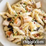 Creamy chicken bacon ranch pasta in a shallow white bowl, garnished with fresh herbs, ready to be served.